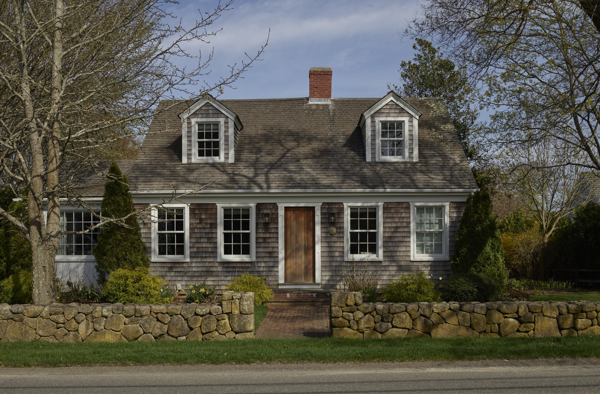 A classic wood-shingled Edgartown house behind its stone wall